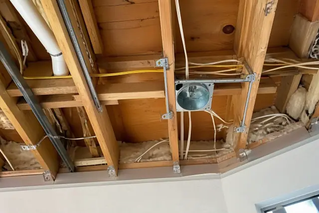 Recessed lighting installation with wiring and housing clips in a residential ceiling in Phoenix, AZ.
