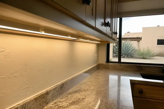 LED under-cabinet lighting installed in a Scottsdale, AZ kitchen with desert landscaping visible through the window.