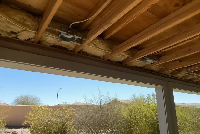Exposed ceiling joists with insulated wiring and lighting clips during an electrical installation in Goodyear, AZ.