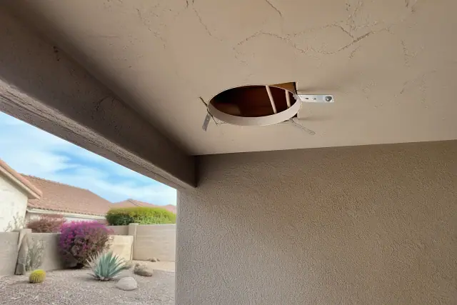 Recessed lighting installation in progress at a home in Sun City, AZ, showing exposed ceiling joists and wiring.