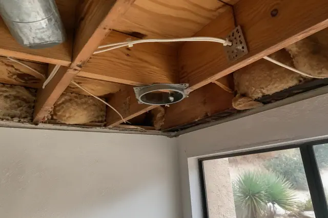Recessed lighting housing and wiring inside a ceiling joist cavity at a job site in Phoenix, AZ.
