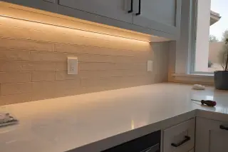 LED under-cabinet lighting strips and a screwdriver on a kitchen counter in a Phoenix, AZ home.