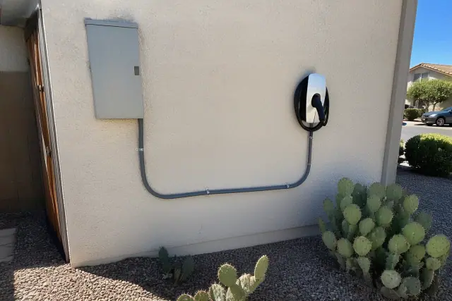 EV charger installed on a stucco wall with conduit piping at a home in Phoenix, AZ.