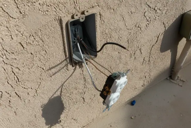 Exposed electrical wall box with copper wiring for an outlet installation in Phoenix, AZ.