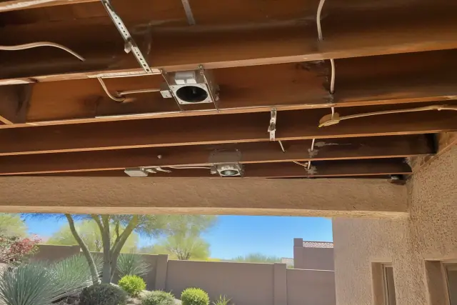 Recessed lighting installation with wiring and housing clips in a ceiling joist, viewed from a jobsite in Phoenix, AZ.