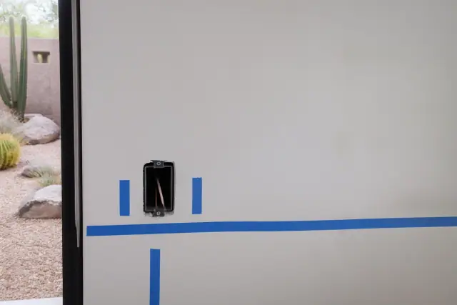 Masking tape layout for a new wall outlet installation in a Phoenix, AZ residential job site.
