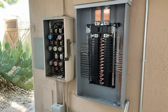 A new electrical panel installation replacing an old fuse cabinet on a stucco wall in Phoenix, AZ.