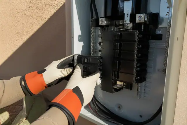 Electrician installing single-pole and double-pole circuit breakers in a Phoenix, AZ residential panel.