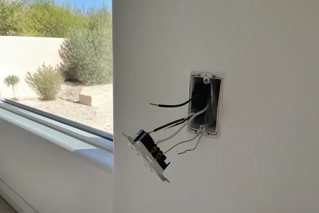 Exposed electrical wall box with copper wiring for a receptacle installation in a Phoenix, AZ home.
