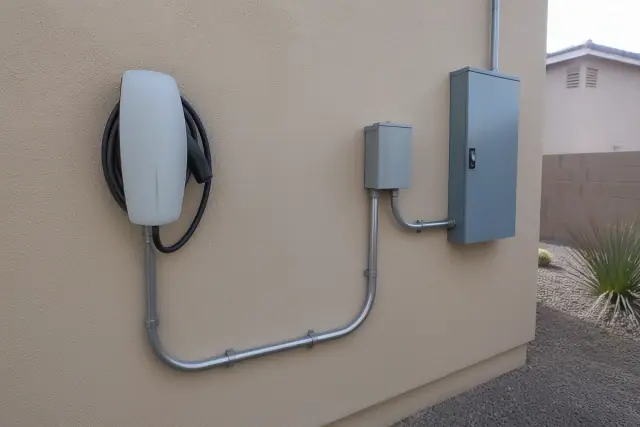 EV charger installed on a stucco home wall with conduit piping in Phoenix, AZ.