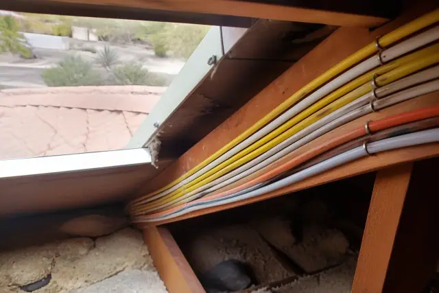 New electrical wiring neatly stapled to rafters in an attic during a whole home rewiring project in Mesa, AZ.