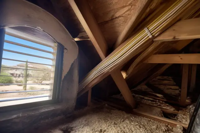 New electrical wiring bundle stapled to rafters in a residential attic during a home rewiring project in Chandler, AZ.