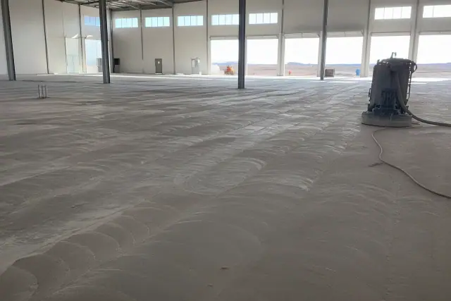Unfinished concrete floor with grinder marks inside a logistics warehouse in Phoenix, AZ.