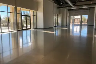 Polished concrete retail floor reflecting desert sunlight through large glass windows in Phoenix, AZ.