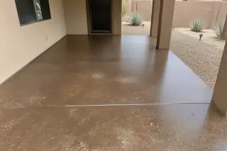 Stained concrete patio with earth-tone finish and agave landscaping in a Phoenix, AZ backyard.