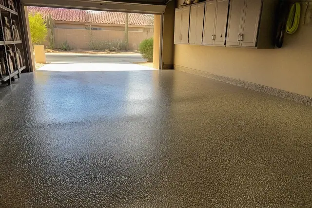 Freshly applied epoxy flake floor in a residential garage with desert landscaping visible outside in Phoenix, AZ.