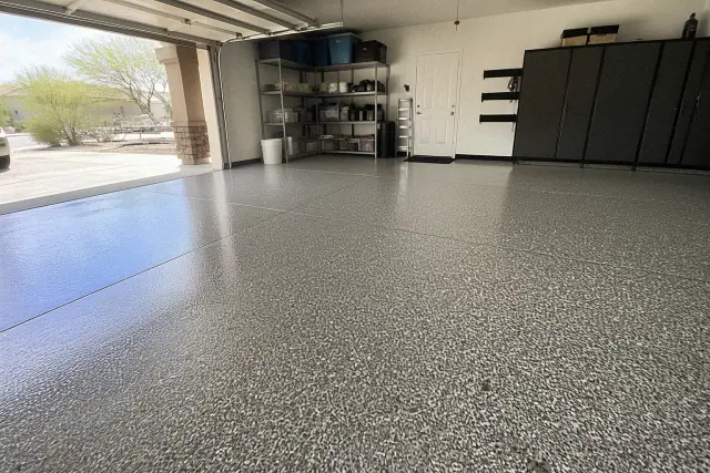 Epoxy flake flooring in a residential garage with desert landscaping visible outside in Queen Creek, AZ.