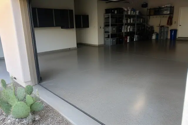 Polished grind and seal concrete floor in a residential garage with utility shelving in Phoenix, AZ.