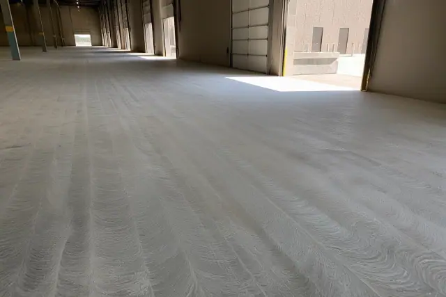 Mid-process grind-and-seal concrete floor with scratch patterns in a Phoenix, AZ warehouse.