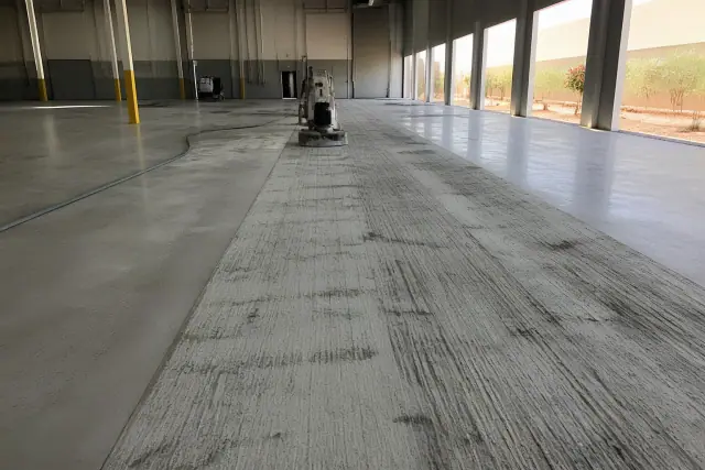 Concrete floor undergoing diamond-grinding surface preparation in an industrial warehouse in Phoenix, AZ.