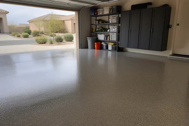 Glossy industrial epoxy flooring in a residential garage in Queen Creek, AZ, with storage cabinets and visible desert