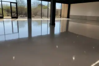 High-gloss industrial epoxy floor in a retail space with desert xeriscaping visible through windows in Phoenix, AZ.