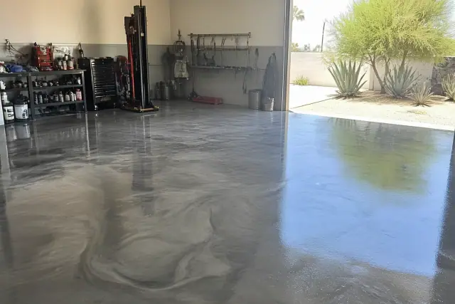 Metallic epoxy floor with marbled silver and charcoal swirls in a vehicle service bay in Phoenix, AZ.