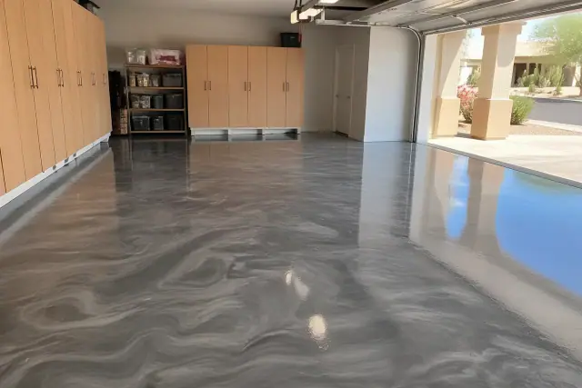 Metallic epoxy garage floor in a Phoenix, AZ home with storage cabinets and desert landscaping visible outside.