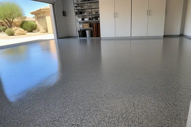 Freshly applied epoxy flooring in a residential garage in Queen Creek, AZ, with desert landscaping visible outside.