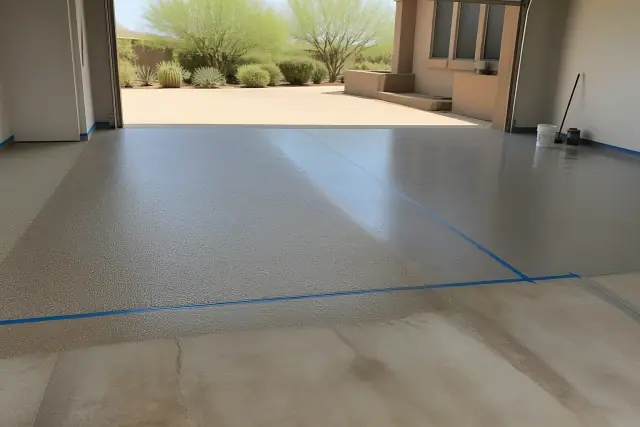 Technician applying epoxy and concrete-finish floor coatings in a residential garage in Phoenix, AZ.