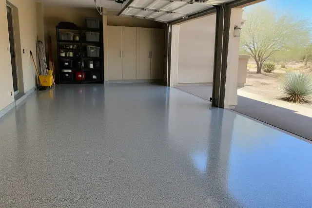 Glossy polyaspartic garage floor coating in a residential Phoenix, AZ home with storage cabinets and desert views.