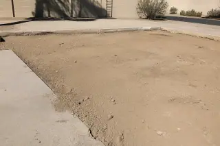 Cleared and leveled ground next to existing concrete slabs at a construction site in Phoenix, AZ.