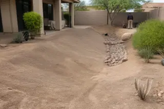 Smoothly graded drainage swale with raked soil and desert landscaping at a Phoenix, AZ construction site.
