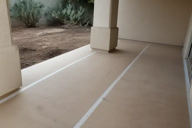 Heavy-duty floor protection film with taped seams on a residential interior surface in Phoenix, AZ.