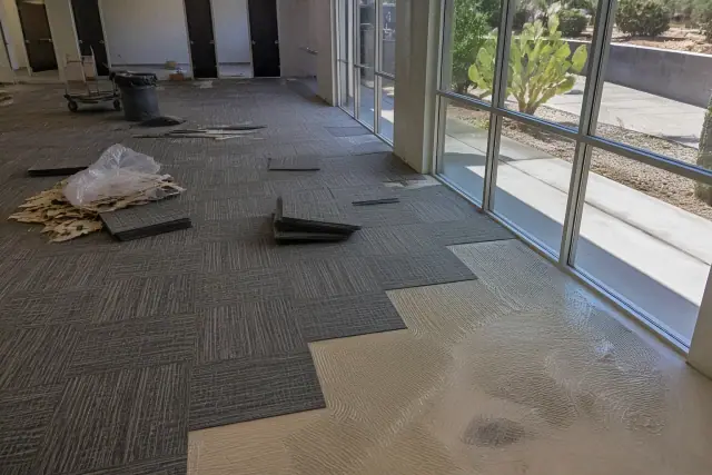 Carpet tiles being installed in a sunny office workspace in Goodyear, AZ.