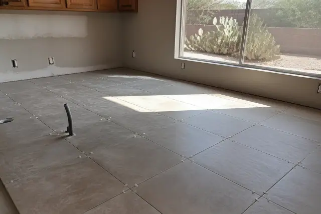 Ceramic and porcelain tile installation on a kitchen floor with spacers in Phoenix, AZ.