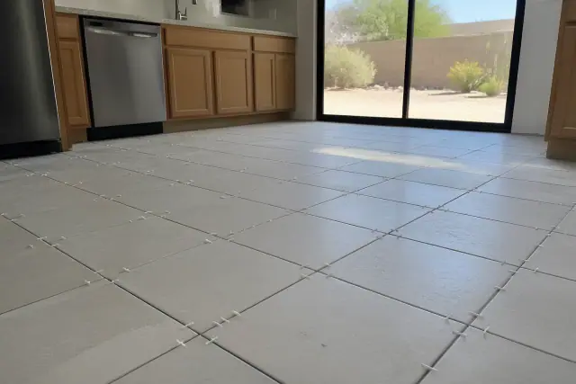 Ceramic tile installation with plastic spacers on a kitchen floor in Phoenix, AZ.