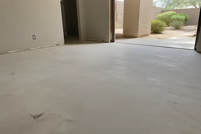Clean, dry concrete subfloor prepared for new flooring in a Phoenix, AZ home with desert landscaping visible outside.