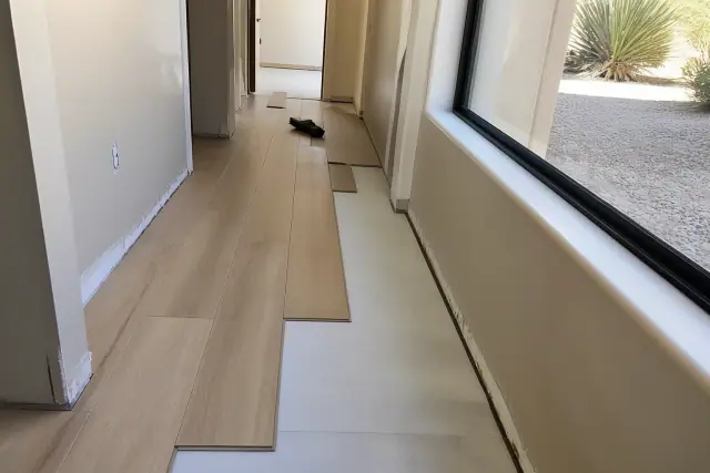 Luxury vinyl plank flooring with a staggered click-lock pattern being installed in a hallway in Phoenix, AZ.