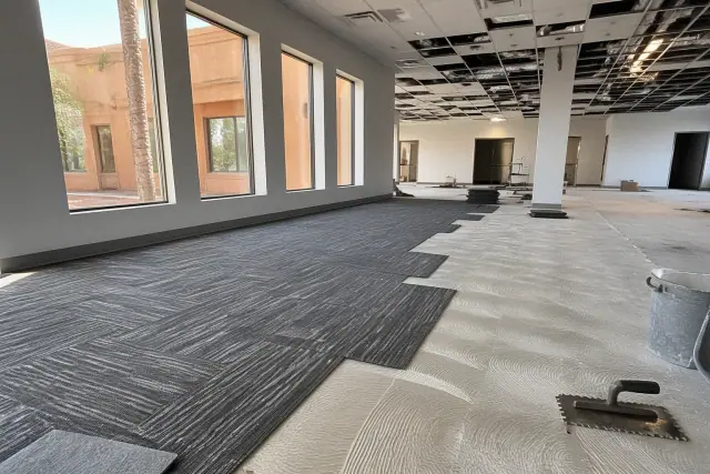 Carpet tiles being installed on a subfloor during an office renovation in Gilbert, AZ.