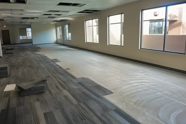 Carpet tile installation in an office workspace with adhesive grid lines, Avondale, AZ.
