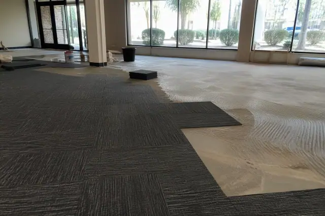 Carpet tile installation in an office renovation with desert views visible through windows in Phoenix, AZ.