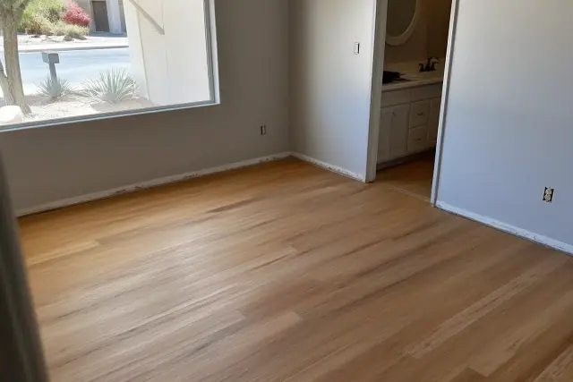 Installed hardwood flooring with visible wood grain and seams inside a residential room in Phoenix, AZ.
