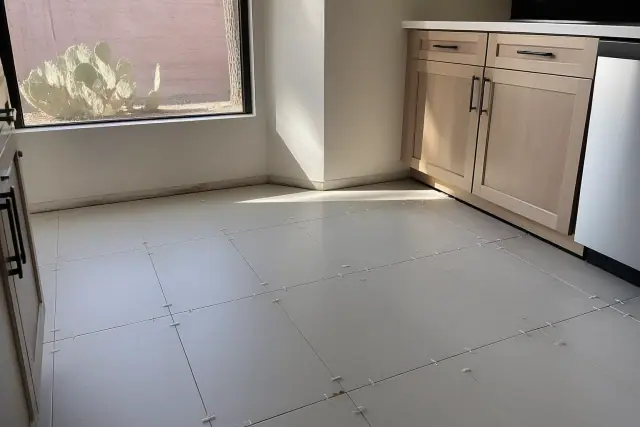 Ceramic floor tiles with spacers aligned on a kitchen floor in Phoenix, AZ.
