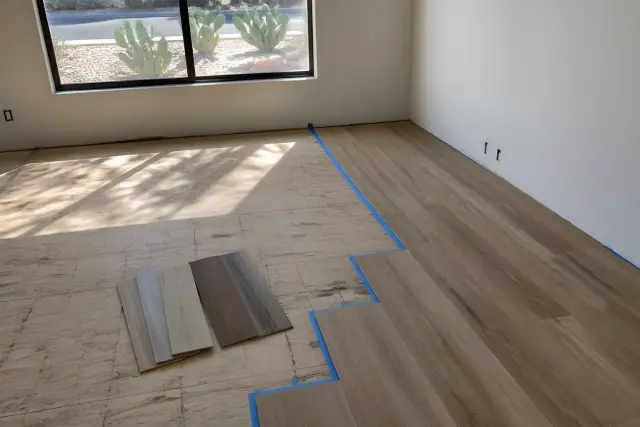 Desert-ready flooring samples laid out on a subfloor in a home in Phoenix, AZ, with prickly pear cacti visible outside.