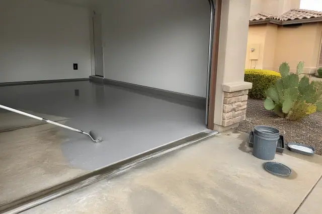High-gloss epoxy resin being rolled onto a residential garage concrete floor in Chandler, AZ.