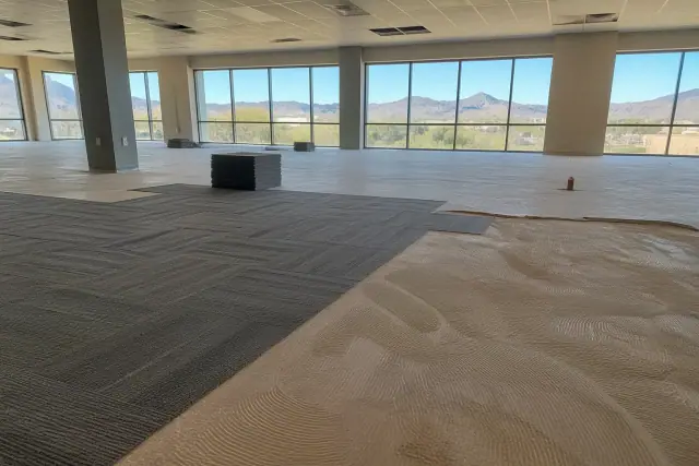 Commercial carpet tile installation during an office renovation with mountain views in Phoenix, AZ.