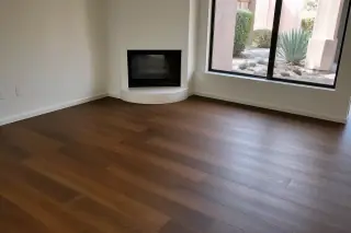 Newly installed hardwood flooring with natural wood grain and desert views through a window in a Phoenix, AZ home.