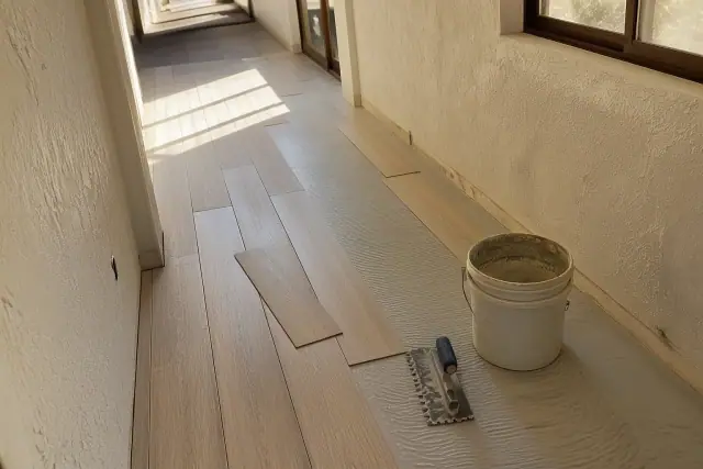 Luxury vinyl plank flooring being installed in a sunny hallway in Phoenix, AZ.
