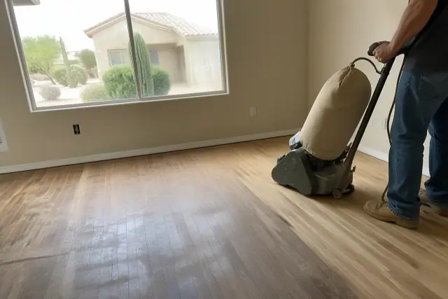 Industrial sander smoothing hardwood bedroom floors during a restoration project in Surprise, AZ.